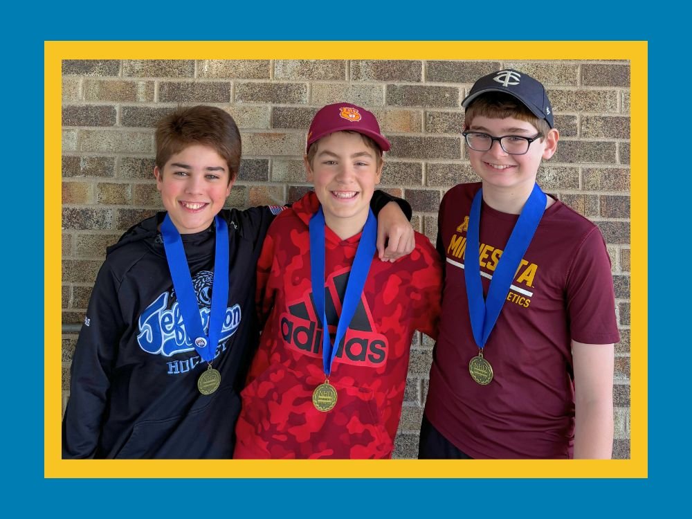 three students wearing their first place medals