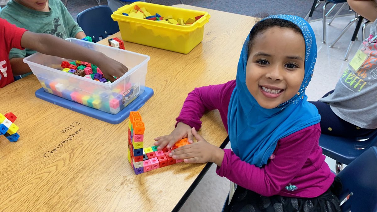 Student plays with connecting blocks at her desk