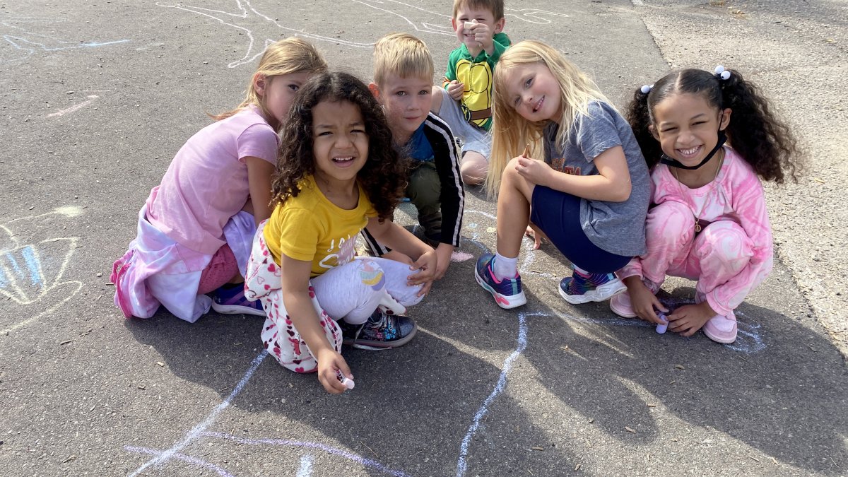 students drawing on pavement with chalk