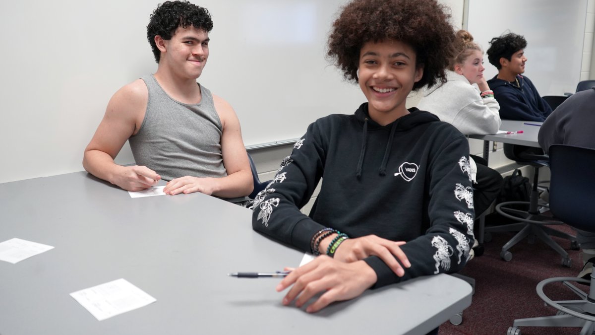two students smiling at a table