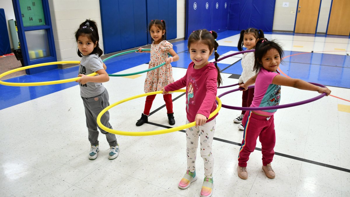 five students in gym with hoola hoops