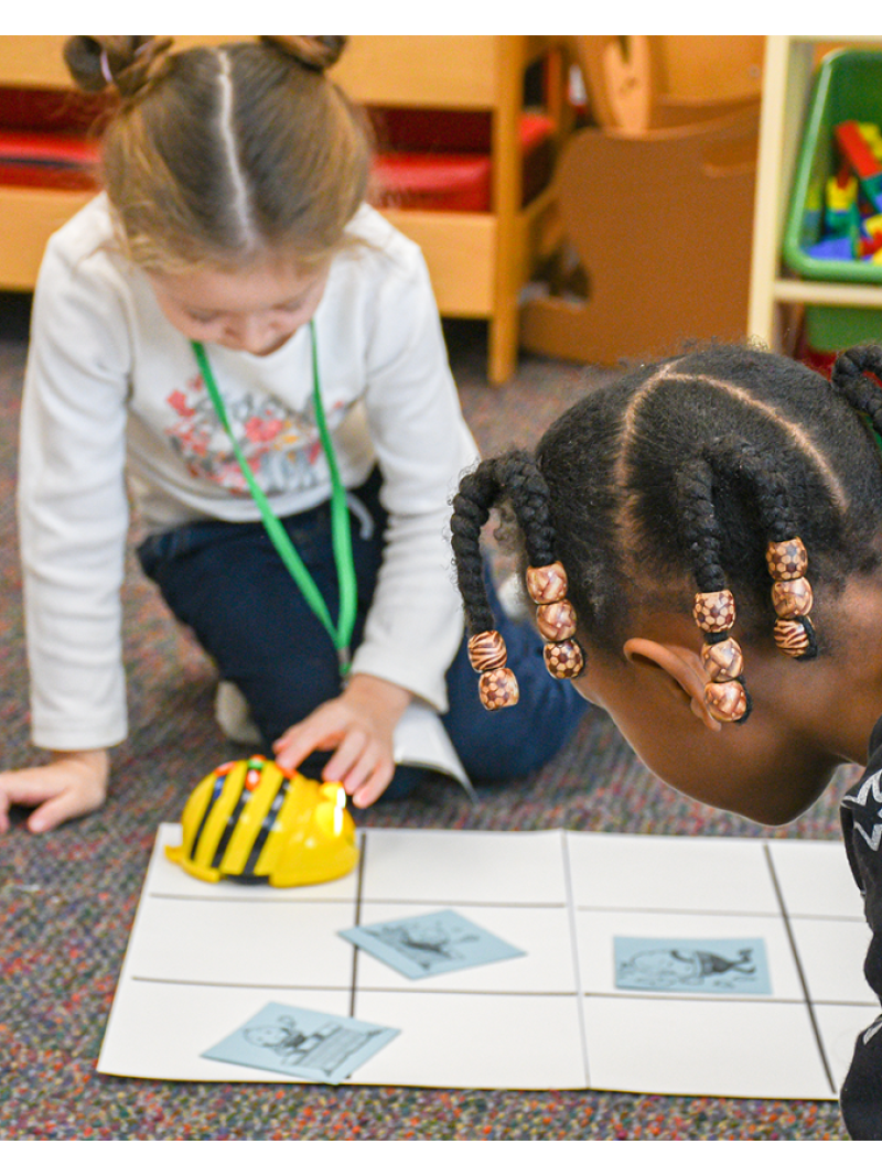 two girls using beebot