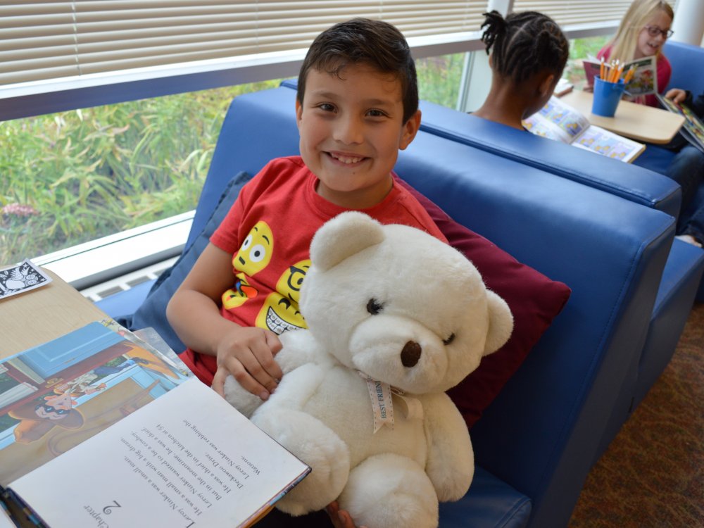 boy reading with teddy bear