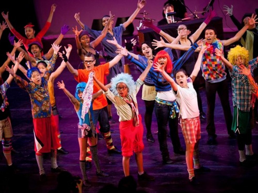 Group of children singing with their hands in the air