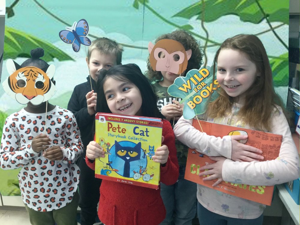 Kids holding books with a jungle background