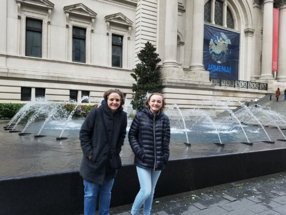 Two woman in front of a fountain outside a museum.