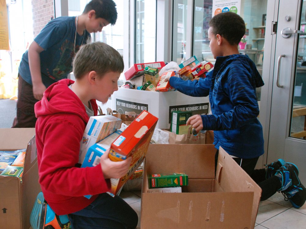 Students loading food donations into large boxes