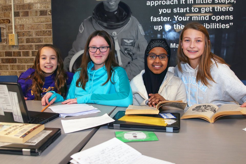 Four students work on homework at a table