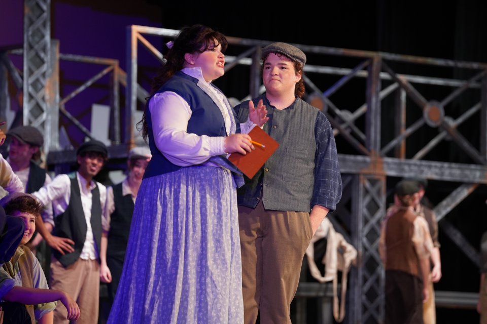 actor and actress performing the musical Newsies on stage